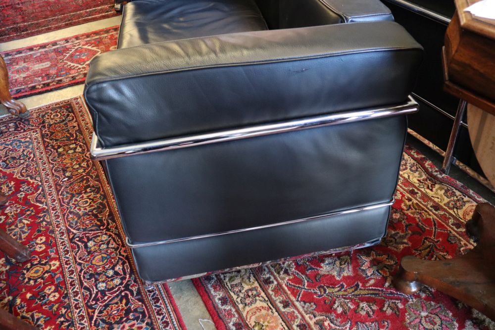 A pair of Corbusier style black leather and chrome two seater sofas, length 130cm, depth 66cm, height 68cm